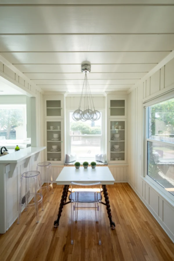 Bright kitchen with white cabinets, an island and wood flooring