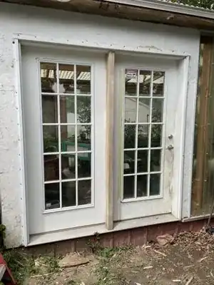 White exterior French doors installed in a stucco wall