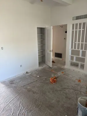 Empty room with the floor covered in protective plastic before a remodel