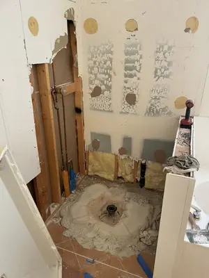 Shower area demolished down to the wall studs before the remodel