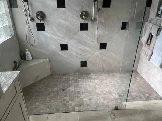 Finished walk-in shower with two shower heads and a tiled bench